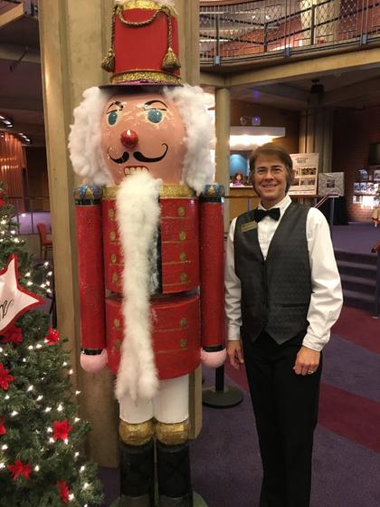Image of a volunteer standing next to a nutcracker