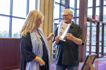 Image of a male showing a female the Hylton Friends brochure